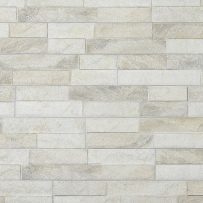 "Through the realistic replication of natural stone, our 3-1/4” x 17-1/2” porcelain subway wall tile transforms any space into a functional and stylish extension of nature. This enlarged rectangular wall tile features an off-set stacked stone pattern in varying shades. With a textured three-dimensional surface, this unique porcelain panel offers organic, rustic beauty. Available in twenty-four print variations that are randomly scattered throughout each case, the variation throughout each tile m Neutral Backsplash Kitchen, Neutral Backsplash, Stone Tile Backsplash, Budget Kitchen Makeover, Fireplace Facade, Merola Tile, Tile Saw, Ceramic Floor Tiles, Faux Brick