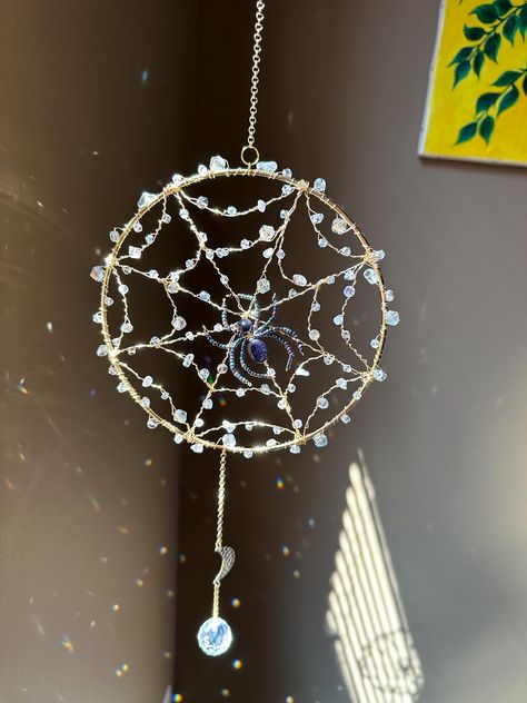 Rain Droplet Spider Web Crystal Prism Suncatcher | Rainbow Maker | Wet look Halloween Window Hanging Sun Catcher Handmade in USA by Marianna Mills Hungarian Artist Add some beautiful, magical sparkles and rainbows to your space or your loved ones with this decorative crystal prism suncatcher.  I wire wrapped white and clear quartz with clear glass crystal beads for spiritual healing properties of these semi precious stones. I hand made the spider with sparkly sandstones and seed beads. The overall length of this suncatcher with the chain is approx. 20,5 inches and 6,5 inches at the widest part.  I design and make them by myself at my art studio in Ellicott City, Maryland, so every each of them are unique.  Your piece may be slightly different from the photo as all of my items are handmade Seed Bead Suncatchers, Wire Wrapped Spider Web, Spider Web Suncatcher, Spiderweb Chandelier, Spiderweb Suncatcher, Spider Suncatcher, Sun Catchers Diy, Beaded Spider Web, Diy Sun Catchers