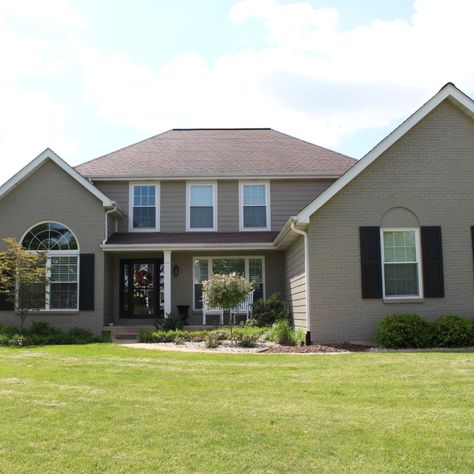 James Hardie Monterey Taupe lap siding was used to make this beautiful house look brand new. The brick on the front elevation was painted to match. James Hardie Monterey Taupe Siding, Taupe Painted Brick Exterior, Monterey Taupe Hardie Siding, Taupe Brick House Exterior, Hardie Monterey Taupe, Houses With Black Windows, Taupe Siding, Vinyl Siding House, Brick Exteriors