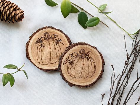 A set of two (2) woodburned coasters. Each one with a unique hand burned rustic pumpkin!  They are hand-burned on locally sourced, live edge Douglas-fir rounds. The coasters are then finished with 2 coats of a clear polycrylic for wood protection against heat and moisture from various beverages!  Coasters have beautiful natural live-edge bark, and are of course perfectly flat. This set is the perfect addition to any table, desk, or home!  *Always unique, hand-drawn and hand-burned with Westcoast Wood Burned Pumpkins, Woodburned Coasters, Engraver Pen, Fall Coasters, Pumpkin Coasters, Engraved Wood Coasters, Bedknobs And Broomsticks, Woodburning Projects, Rustic Pumpkin