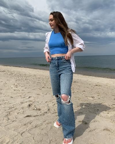 Sara is at the beach wearing garage clothing ripped wide leg jeans and a blue crop top from glassons. she is wearing an open white button up on top and white sandals from boohoo Beach Outfit White, Classy Beach Outfit, Button Up White Shirt, Button Up Outfit, White Shirt Outfit, White Shoes Outfit, Garage Jeans, White Shirt Outfits, Garage Clothing