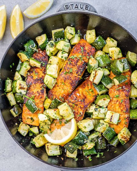 top view salmon filets cook on a black skillet with chunks of zucchini Baked Salmon And Zucchini, Squash And Salmon Recipes, Salmon With Zucchini And Squash, Salmon Low Cholesterol Recipes, Salmon And Squash, Salmon Zucchini Recipes, Salmon Chunks Recipe, Salmon Low Carb Recipes, Salmon And Zucchini Recipes