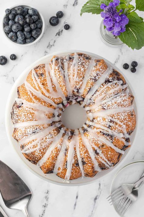 Moist, fluffy and bursting with fresh, juicy berries, Blueberry Sour Cream Coffee Cake is an impressive treat for anytime of day. The swirl of cinnamon sugar and tangy-sweet lemon glaze elevate this easy-to-make Bundt recipe to extraordinary heights of flavor! Blueberry Cinnamon Coffee Cake, Blueberry Sour Cream Coffee Cake Recipe, Sour Cream Blueberry Bundt Cake, Blueberry Sour Cream Coffee Cake Bundt, Jewish Blueberry Sour Cream Bundt Cake, Blueberry Sour Cream Coffee Cake, Cranberry Coffee Cake, Blueberry Banana Smoothie, Bundt Recipes