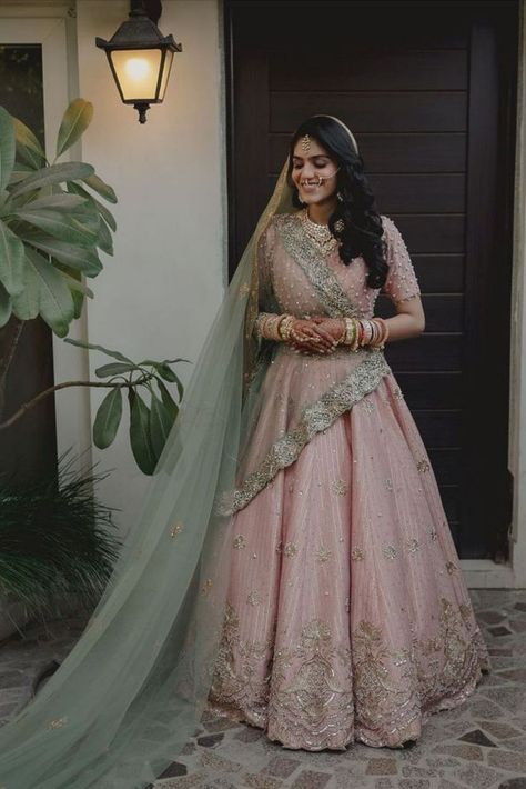 When it comes to wedding lehengas, red has always been a favourite with brides. But off late, brides are giving the traditional red lehenga a miss and opting for a different and unique hue when it comes to picking up their bridal lehenga – powder pink! A pale shade of pink that is in the pastel family has been a bridal favourite off late for your wedding day. It’s perfect for a day wedding as well as an evening soiree, light enough to not overpower you as well as unique enough to style. Pastel Pink Bridal Lehenga, Pastel Bridal Lehenga, Pastel Pink Lehenga, Pink Indian Wedding, Green Bridal Lehenga, Bridal Lehenga Images, Sabyasachi Lehenga Bridal, Pink Bridal Lehenga, Pastel Pink Weddings