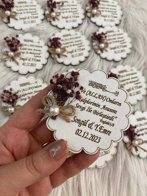 "\"Cherish your special day with our exquisite Wooden Wedding Magnet. Handmade and personalized, it makes a perfect guest gift. Adorned with dried flowers and pearls, this unique magnet is a timeless keepsake.\" Unveil lasting memories with our artisan-crafted Wooden Wedding Magnets--where every detail is a promise of personalized perfection. Why settle for ordinary wedding favors when you can enchant your guests with a timeless blend of nature and craftsmanship? *The wooden magnet is decorated with dried flowers and pearls. *The text can be changed upon request. *Dried flowers are available in natural colors such as pink or dark blue upon request. Charming, personalized, and a lasting reminder of your special day--this handmade wooden magnet with dried flowers and pearls makes for a uniqu Wedding Magnets, Flowers And Pearls, Unique Magnets, Magnet Collection, Personalized Wedding Decor, Wedding Magnet, Wooden Magnets, Wedding Gifts For Guests, Guest Gifts