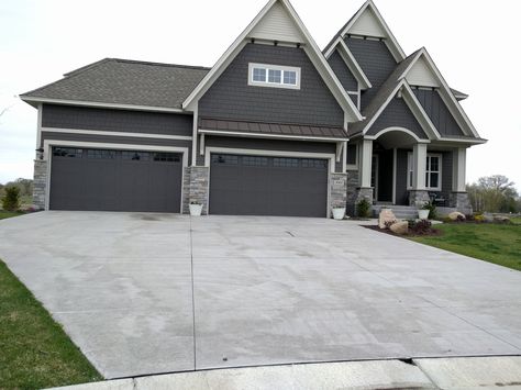 Dark Grey siding and dark garage doors. Nice Stone accents. Grey House Black Garage Door, Dark Gray Garage Door, Black Garage Doors Grey House, Gray House Black Garage Door, Dark Grey Garage Door, Garage Trim, Grey House White Trim, Dark Grey Siding, Dark Garage