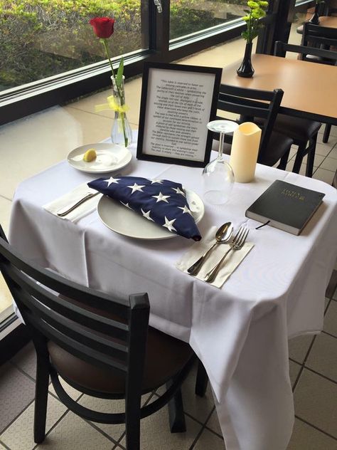 "This table is reserved to honor our missing comrades in arms. The tablecloth is white — symbolizing the purity of their motives when answering the call of duty. The single red rose, displayed in a vase, reminds us of the life of each of the missing and their loved ones and friends of these Americans who keep the faith, awaiting answers. The vase is tied with a yellow ribbon, a symbol of our continued determination to account for our missing. A pinch of salt symbolizes the tears endured by those Fallen Soldier Table, Missing Man Table, Dinner Table Set Up, Dinner Table Set, Fallen Soldiers, Single Red Rose, Memory Table, Fallen Soldier, Dinner Table Setting