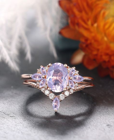 Step back in time with our Vintage Oval Lavender Amethyst Wedding Ring Set, a testament to the timeless beauty of nature-inspired design. Crafted to perfection, this set features an enchanting oval lavender amethyst gemstone embraced by delicate gold art deco leaf motifs. The unique cluster design of the rings, reminiscent of a blooming branch, adds an extra touch of elegance and charm. Each detail is meticulously crafted to capture the essence of nature's beauty, making this set a truly special Non Traditional Engagement Rings Purple, Purple Engagement Ring, Wedding Ring Set Unique, Amethyst Wedding Ring, Amethyst Wedding Rings, Wedding Ring Sets Unique, Amethyst Wedding, Shiny Rings, Ring Inspo