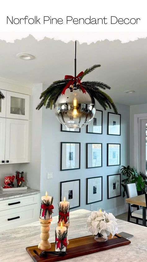 53K views · 610 reactions | Elevate Your Kitchen with Norfolk Pine Stem Pendant Light Decor. Comment LINK and I'll send you a DM with supplies. Are you looking to add a touch of natural elegance to your home decor? Norfolk Pine stems can be a unique and beautiful choice for creating stunning pendant lights this holiday season. These DIY pendant lights not only infuse a holiday charm but also bring a piece of nature indoors. Here's how you can make your very own Norfolk Pine stem pendant light decor: **Materials You'll Need:** 1. Norfolk Pine stems 2. Ribbon 3. Mini Bells **Step-by-Step Guide: 1. Collect Norfolk Pine Stems: Start by finding some Norfolk Pine stems. I found each of mine for $5. Comment LINK and I'll send you a DM with the exact stems I used. 2. Cut the Stems: Use wi Kitchen Light Christmas Decor, Pendant Lights Christmas Decor, Pendant Light Christmas Decorations, Christmas Decor Pendant Lights, Pendant Lights Over Kitchen Island Christmas Decor, Decorating Pendant Lights For Christmas, Decorate Pendant Lights For Christmas, Pendant Light Christmas Decor, Christmas Pendant Light Decor