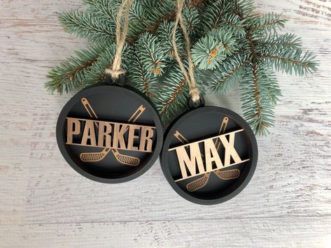 "This 3.5\" Personalized Hockey Puck Ornament makes a great Graduation gift for your favorite hockey player!  Made of 3 layers of wood with your name cut out and finished back. Strung with jute twine and your choice of Maple (light wood) or Walnut (dark wood) for the name. Name height will vary depending on how many letters are in the name. The year \"2023\" can be engraved below the hockey sticks engraving and a jersey number can be engraved above the hockey sticks.   Please note wood color and Hockey Ornaments Diy, Hockey Christmas Ornaments, Hockey Team Gifts, Hockey Ornaments, Hockey Player Gifts, Hockey Christmas, Hockey Decor, Hockey Birthday, Hockey Coach