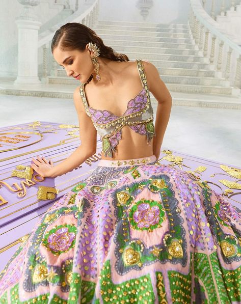 A multicolored floral lehenga featuring pockets and adorned with intricate golden embroidery. Paired with our iconic bradshaw blouse, crafted from luxurious velvet and tulle with metallic embellishments, along with a lilac tulle dupatta. Butterfly Indian Outfit, Butterfly Lehenga Blouse, Butterfly Lengha, Multicolor Lehenga, Peach Lehenga, Golden Embroidery, Bohemian Wedding Decorations, Floral Lehenga, Lehenga Blouse