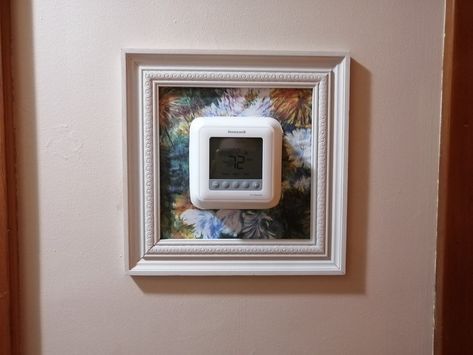 Frame Around Thermostat, Hide Fire Alarm On Wall, Thermostat Wall Decor, Hide Thermostat On Wall, Nest Thermostat Decor, Thermostat Cover Ideas, Hide Thermostat, Thermostat Cover, House Basement