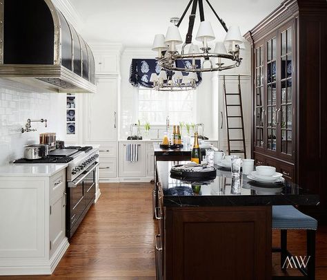 A cook's kitchen features pair of black leather strap chandeliers, Ralph Lauren Westbury Chandeliers, illuminating side by side walnut islands topped with black marble facing a walnut china cabinet with glass doors. Kitchen Deisgn, Walnut Kitchen Cabinets, Cooks Kitchen, Calcutta Gold, Main Kitchen, Patina Farm, Front Kitchen, Grey Kitchen Island, Vision Book