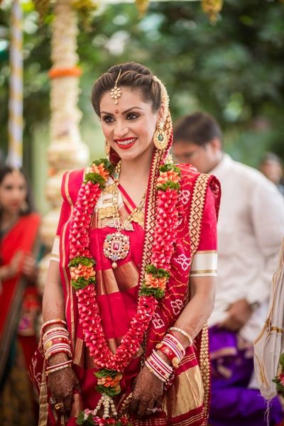 South Indian Bride - Bride in a Red and Gold Kanjivaram Saree with a Red and Orange Floral Garland | WedMeGood #wedmegood #indianbride #southindianbride #southindianoutfit #kaanjivara #red #gold Gujarati Bride, विवाह की दुल्हन, Indian Wedding Garland, Gujarati Wedding, Wedding Crashers, Indian Wedding Photos, Indian Bridal Makeup, Asian Bride, South Indian Bride