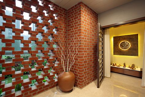 Perforated brick clad walls with the garden outside makes this a calm and serene pooja room befitting for a bungalow. Concrete Bungalow, Brick Wall Design, Brick Feature Wall, Brick Works, Indian Interiors, Indian Home Interior, Pooja Room Design, Brick Architecture, Brick Facade