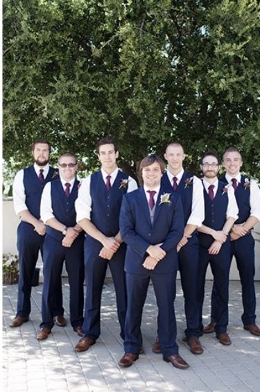 Groomsmen party- Groom in Navy Blue suit with a white shirt and purple tie. Groomsmen in navy blue pants and vest with white shirt and purple tie. All with brown belts and brown shoes. Groomsmen Attire Navy Burgundy, Groom And Groomsmen Attire Purple, Navy Blue Vest Groomsmen, Blue And Purple Groomsmen Attire, Groomsmen Vest Attire, Navy Vest Groomsmen, Navy Suit Purple Tie, Navy Blue Groomsmen Attire, Groomsmen Attire Purple