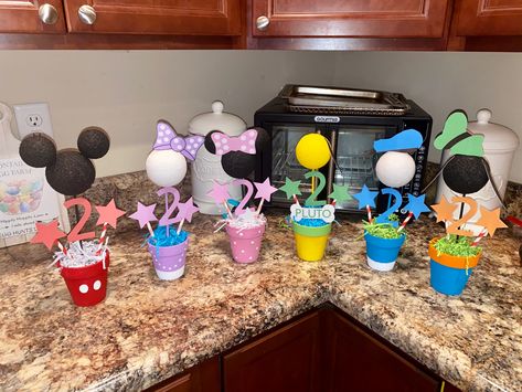 I made these with small flower pots, acrylic paint and cardstock. Mickey Mouse Birthday Flowers, Mickey Mouse Flower Arrangement, Mickey Mouse Clubhouse Centerpieces, Mickey Mouse Clay Pot, Mickey Mouse Clubhouse Decorations, Mickey And Friends Centerpieces, Mickey Clubhouse Cake Table, Mickey Mouse Centerpieces, Mickey Mouse Birthday Decorations