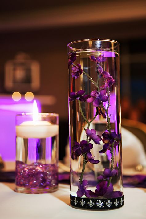 Purple Floating Centerpiece in Cylinder Vase Purple Floating Candles, Wedding Centerpieces Cylinder Vases, Floating Flower Centerpieces, Cylinder Vase Centerpiece, Glass Vase Wedding Centerpieces, Glass Wedding Centerpieces, Flower Centerpieces Diy, Floating Centerpieces, Gold Wedding Flowers