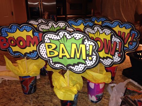 Centerpieces! I made these for Tre's 3rd Birthday using the superhero plastic cups found in the party section of Wal-mart, wrapped floral foam with tissue paper, used bamboo skewers to attach comic word printout with a black card stock backing. Superhero Gala, Superhero Centerpiece, Superheroes Birthday Party, 4th Of July Ideas, Rs Activities, Girl Superhero Party, Power Ranger Party, Comic Party, Wonder Woman Party