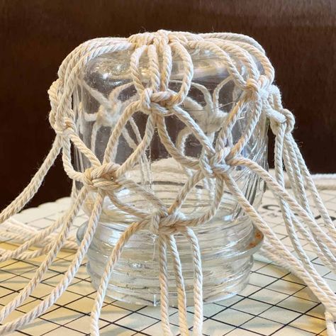 DIY Macrame Glass Jar Covers Made with Square Knots Macrame Glass Jar, Diy Macrame Projects, Mason Jar Hanger, Macrame Candle Holder, Jar Covers, Macrame Plant Hanger Patterns, Simple Macrame, Macrame Knots Pattern, Diy Macrame Plant Hanger