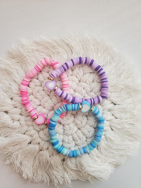 Pink, Blue, Purple clay heart heishi bracelets! Spring Bracelets, Selling Bracelets, Beaded Bracelet Diy, Seed Bead Bracelets Diy, Kawaii Bracelet, Bracelet Business, Heishi Bracelets, Clay Bracelets, Beaded Braclets