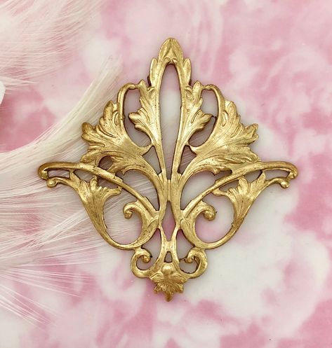 "Style: Filigree acanthus Leaf Stamping Finish: Raw Brass Quantity: 1 Piece Origin: Made in the USA approximately Size: Height: 2\" Width: 2\" Gold Tone Item Does Not Have a Loop or Hole. Item Has a Hollow Back. If you do not see the quantity that you need, please contact us. We may be able to accommodate your custom request. ----ღஐ SHIPPING ஐღ--- Shipping may be combined on multiple items purchased in one payment. If payments are made separately, shipping cannot be combined. For declaration amo Leaf Stamping, Stamping Jewelry, Flourish Design, Brass Filigree, Tattoo Lettering Fonts, Lace Mask, Oxidized Brass, Acanthus Leaf, Silver Lockets