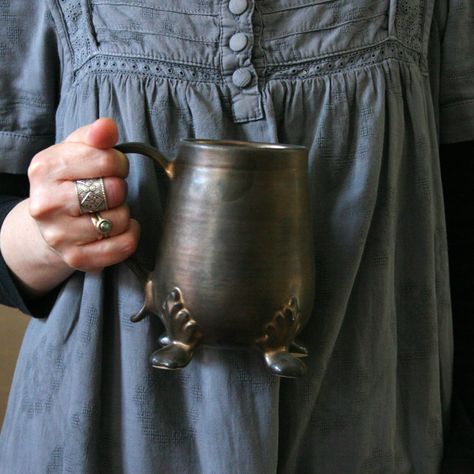 Ceramic mug with artistic handle and legs, glazed with an old gold glaze.Wheel thrown mug for mulled wine, wine, tea, coffee...The mag is handmade on a potter’s wheel, and the handle and legs are handsculpted.Because each mug is individually and completely handmade, the one I'll post to you is going to be a little different in shape and final result of glaze, from the one in the photos. Each item is individually wheel thrown All our glazes are leadfree and foodsafe. All our dishes are microovend Pottery Mug For Men, Ren Faire Mug, Ceramics Handles Ideas, Glazing Black Clay, Gothic Ceramics, Fantasy Pottery, Functional Pottery Ideas, Funky Ceramics, Crazy Ceramics