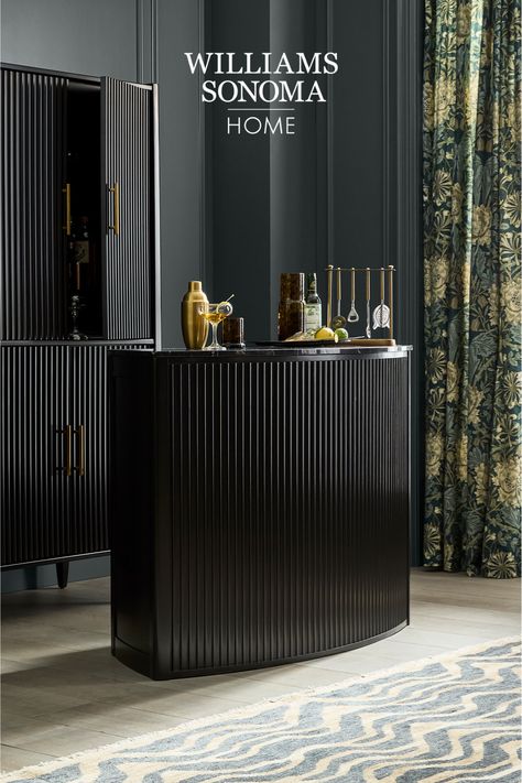 Entertain in thoroughly modern style with our Lewis bar, an eye-catching essential with a distinctive curved profile, fluted detailing and smoothly honed black marble top. The polished yet practical piece is fitted with two soft-closing drawers, open shelving and a stemware rack that holds all the glasses you need for cocktail hour. High End Bar, Waterfall Island Kitchen, Dining Table Guide, Kitchen Workshop, Bar Cabinets, Home Bar Rooms, Stemware Rack, Open Cabinets, Bar Essentials