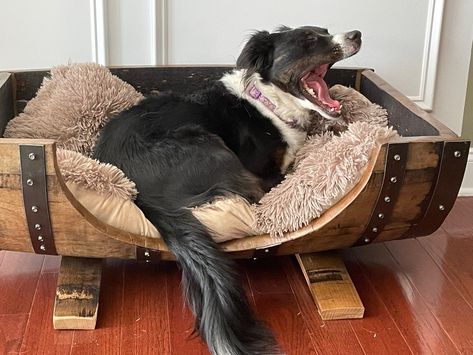 Would your dog like a new comfy bed made from a real whiskey barrel? You bet he or she does! Our dog beds are made from real, used whiskey barrels. Each bed is hand sanded and the loose char is removed. Multiple clear coats are applied to create a very durable finish. The interior of the bed is approximately 32" long by 23" wide. Exterior dimensions are approximately 35" long by 26" deep by 20" high. All barrels are unique so all dimensions may differ by an inch or so. We do not include the pill Barrel Dog Bed, Rustic Dog Beds, Used Whiskey Barrels, Wooden Pet Bed, Dog Food Station, Dog Cave, Ranch House Decor, Barrel Decor, Whiskey Barrels