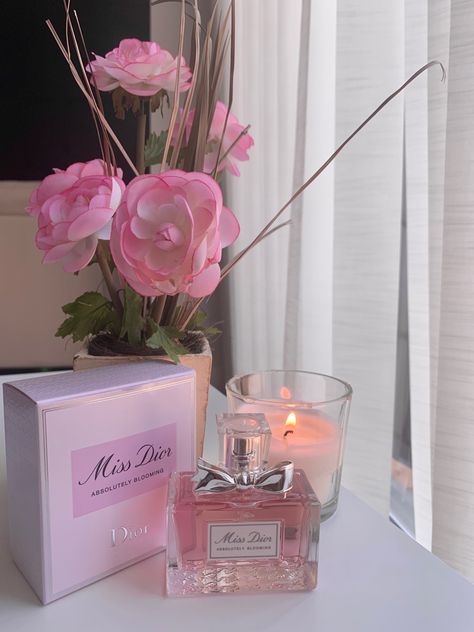 pink aesthetic image, there is a Miss Dior Absolutely Blooming perfume on the table, along with the box, and pink flowers in the background Dior Aesthetic Pink, Pink Dior Aesthetic, Perfume Aesthetic Vintage, Miss Dior Aesthetic, Miss Dior Absolutely Blooming, Aesthetic Perfumes, Dior Absolutely Blooming, Absolutely Blooming, Scents Perfume