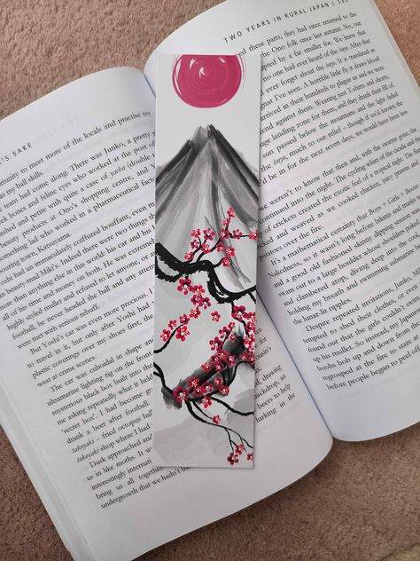 Introducing our exquisite Japanese Mountain and Sun Bookmark - a delicate fusion of natural beauty and cultural symbolism. Crafted with precision and inspired by the breathtaking landscapes of Japan, this bookmark is more than just a page holder; it's a piece of art that tells a story. Elevate your reading experience and immerse yourself in the beauty of Japan's majestic landscapes and the tranquility of its sunrises with our Japanese Mountain and Sun Bookmark. With each turn of the page, you'll be reminded of the enduring connection between nature and the human spirit. Order yours today and embark on a literary journey filled with inspiration and wonder. The Dimensions are 2inches by 8inches high. It is ONE sided and made of 1mm White Foam Board. Perfect for any gift :) Japanese Bookmarks Art, One Piece Bookmark, Sun Bookmark, Japanese Bookmark, Bookmark Creative, Japan Watercolor, Page Holder, Bookmark Printing, Japanese Symbol