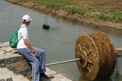 A boy watches a radio-controlled boat in the town of Smiljan, Croatia, Nikola Tesla's hometown. Nearby is a bladeless waterwheel turbine of Tesla's design. The same principle powers his famous turbine engine. Tesla Turbine, Tesla Patents, Radio Control Diy, Water Turbine, Nicolas Tesla, Radio Controlled Boats, Turbine Engine, Solar Energy Diy, Free Energy Generator