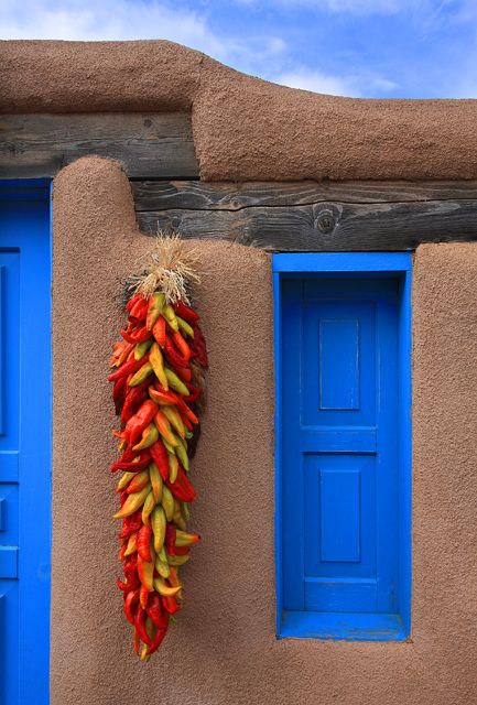 Chile ristras are common decorations around doors and windows on homes in New Mexico  #KlausPriebe Chile Ristra, Southwestern Landscape, Southwest Living, New Mexico Style, New Mexico Homes, Blue Doors, Taos New Mexico, Mexico Style, Adobe House