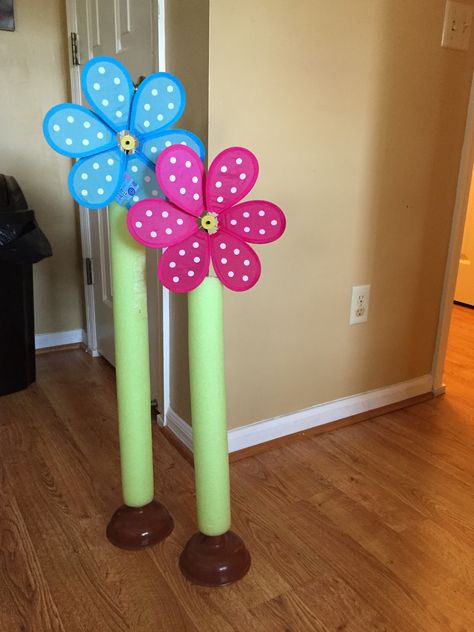 For VBS. Just made these from 2 plungers, 2 large flowers pinwheels. And one swim noodle . All from dollar tree. Now I want more! Pool Noodle Classroom Decorations, Pool Noodle Yard Decor, Pool Noodle Party Decorations, Vbs Garden Theme, Pool Noodle Flowers Diy, Pool Noodle Flowers, Magnified Vbs 2025, Vbs Magnified, Spring Fling Party