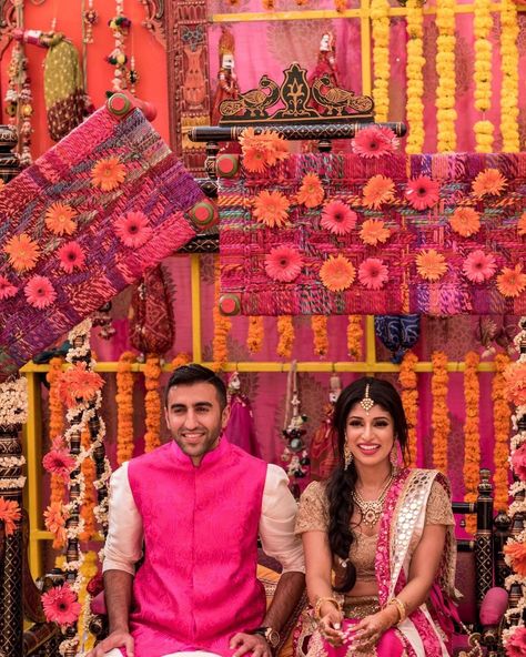 Decor by BAQAA Glamour Weddings & Events | bride and groom in matching pink outfits | lovely floral decor in the background | pink and orange floral decor looks lovely and very unique| #wittyvows #bridesofwittyvows  #lehenga #bridallehenga #groom #sherwani #sherwanigroom #sherwaniformenindiangroom #decor #background #backgrounddesign #flowers #floraldesign #indianwedding #indianweddingphotography Unique Haldi Outfits For Bride And Groom, Haldi Pink Outfit, Gown Poses Ideas, Haldi Outfits For Bride And Groom, Pink Haldi Outfit, Unique Haldi Outfits For Bride, Haldi Groom, Haldi Outfits For Bride, Floral Decor Ideas