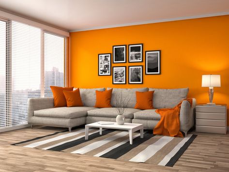 Orange never fails to give life to a dim and lonely living room. The wall in bright and cheerful orange is supported with the orange throw pillows and orange cloth resting on the sofa. Bright Orange Living Room, Orange Wall Living Room Ideas, Bright Wall Colors For Living Room, Orange White Living Room, Orange Wall Paint Ideas, Orange Walls Living Room, Orange And Gray Living Room, Living Room Designs Color, Living Room Wall Colour Ideas