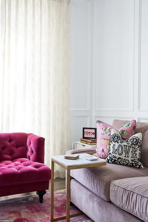 Chic contemporary living room boasts a mauve velvet sofa placed on a pink rug in front of a wall covered in floor-to-ceiling wainscoting. Mauve Velvet Sofa, Blush Pink Velvet Sofa, Couch Pink Velvet, Pale Pink Velvet Sofa, Pink Long Velvet Couch, White Curtains Living Room, Velvet Sofa Living Room, Pink Velvet Sofa, Velvet Tufted Sofa