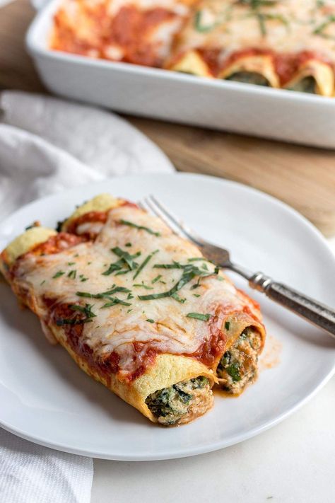 Two low carb spinach manicotti on a white plate with a fork and a baking dish of cooked manicotti in the back ground. Recipes With Ricotta, Recipes With Ricotta Cheese, Keto Alfredo, Low Carb Crepe, Spinach Manicotti, Keto Entrees, Keto Chips, Tartiflette Recipe, Ricotta Cheese Recipes