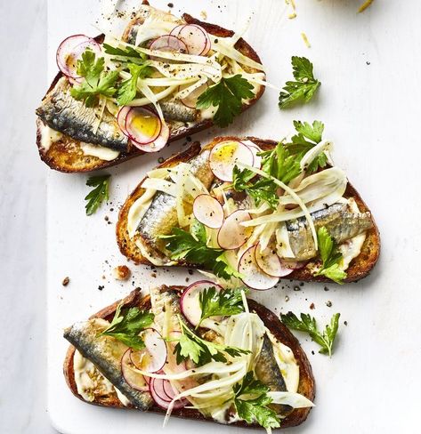 Think of this as a tuna sandwich with an elegant, adult twist. First, you’ll make a lemony garlic mayo to spread on toasted multigrain bread. You’ll nestle sardine fillets into the schmear, and pile a fresh fennel-radish salad on top. If you want a more filling meal, add a white bean salad or sliced summer tomatoes sprinkled with flaky sea salt. Sardine Toast, Tin Fish, Sardine Recipes, Mayo Recipe, Multigrain Bread, Canned Fish, Tinned Fish, Garlic Mayo, Radish Salad