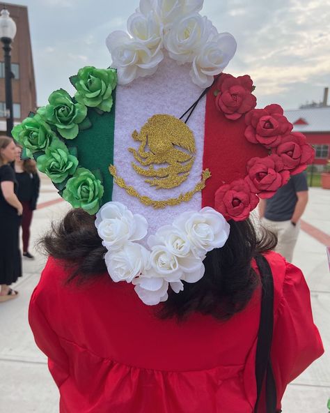 mexican flag design on a graduation cap. the eagle symbol made with a glitter gold foam sheet, the flag colors made with felt sheets. and bordered around the cap with small flowers the colors of each side of the flag. Mexican Flag Graduation Cap, Grad Cap Mexican, Grad Cap Ideas Mexican, Graduation Cap Designs Mexican, Flag Graduation Cap, Class Of 23, Grad Cap Ideas, Mexican Graduation, Caps Ideas