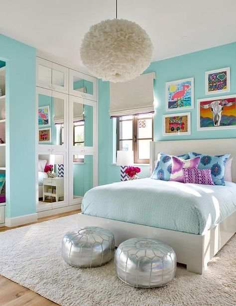 Turquoise blue girl's bedroom features a white feather chandelier, Eos White Pendant, illuminating a white wingback bed dressed in pale blue bedding as well as blue and purple paisley pillows tucked under an eclectic art gallery placed next to casement windows covered in a white roman shade accented with purple tassel trim. Girls Blue Bedroom, Turquoise Room, Bedroom Turquoise, Decor Ikea, Bilik Tidur, Girl Bedroom Designs, Trendy Bedroom