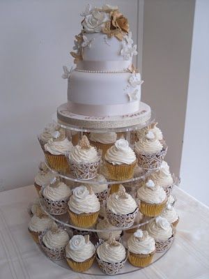 silver, Gold and white 2 tier cake with cupcake tiers Wedding Cakes 2 Tier, Cakes 2 Tier, Golden Wedding Anniversary Cake, Cake With Cupcakes, Wedding Cupcakes Rustic, Wedding Cake Table Decorations, 50th Wedding Anniversary Cakes, Cupcake Tower Wedding, Wedding Anniversary Cakes