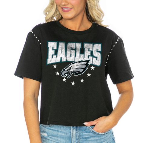 The Women's Gameday Couture Black Philadelphia Eagles Gladiator Studded Sleeve Cropped T-Shirt is the perfect way to show unwavering support for the Philadelphia Eagles. This stylish and comfortable tee features distressed screen print graphics, a mid-length crop, and an oversized fit. The studded detail across the shoulders and sleeves adds an edgy touch to this must-have game day essential. Whether cheering from the stands or watching from home, this Philadelphia Eagles T-shirt is sure to make Philadelphia Eagles T Shirt, Carolina Panthers Logo, Atlanta Falcons Logo, Gameday Couture, Tampa Bay Buccaneers, Jacksonville Jaguars, Cropped T Shirt, Atlanta Falcons, Cincinnati Bengals