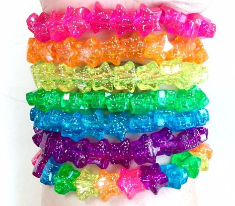 Colorful, sparkling stars in six solid colors and one rainbow! The base of each bracelet is a 6.75-inch strong and stretchy elastic jewelry cord. All beads are plastic. Rainbow Bracelet Beads, Decora Accessories, Glittery Jewelry, Elastic Jewelry, Dreams Core Aesthetic, Rainbow Accessories, Kandi Ideas, Kandi Cuff, Kandi Bracelets