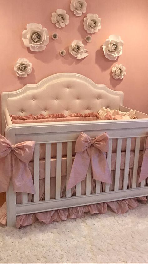 Elegant DIY paper roses and satin bows on a crib with tufted upholstery and dupioni silk baby bedding with ruffles.  Pink baby girl nursery decorating ideas with DIY crafts projects. Crib With Bows, Vintage Crib Bedding, Cute Baby Beds, Pink Crib Nursery, Pink Bow Nursery Theme, Cute Nursery Ideas Girl, Crib Decoration Ideas, Girly Nursery Ideas, Pink Nursery Ideas