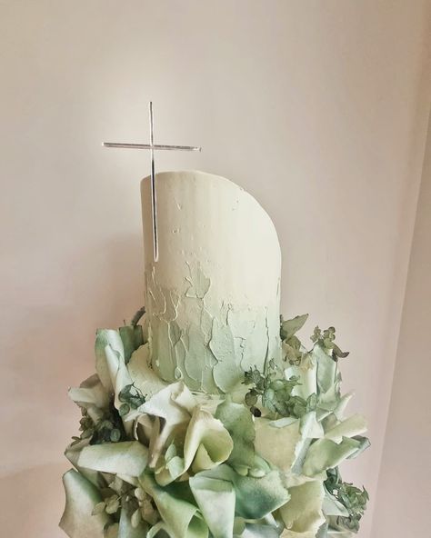 Cream/nude two tier christening cake with textured sage green buttercream elements and sprayed/coloured green wafer sails, and dried green hydrangeas. Top tier is slightly slanted and not straight, has a thin silver mirror acrylic cross cake plaque pasted to the front with bakers paste Sage Green Bautizo, Green Confirmation Cake, Sage Green Birthday Cake With Flowers, Sage Green Cake With Butterflies, Green Baptism Cake, Communion Cake Topper, Communion Cakes, Baptism Cake, Christening Cake