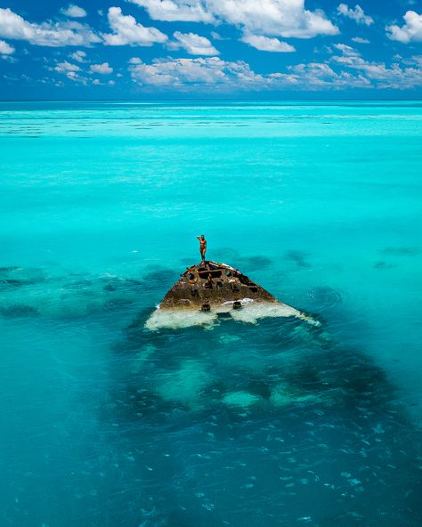 Drone shot of a rusty shipwreck sitting in the turquoise waters of Bermuda. A woman stands on its bow. Bermuda Triangle Video, Dm Logo, The Bermuda Triangle, Bermuda Triangle, Winter Storm, Island Home, Face Photo, Shipwreck, At The Top