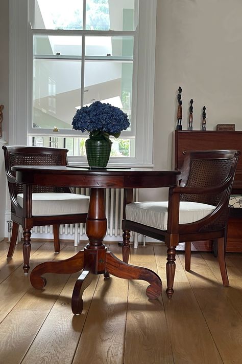 The perfect setting. 2 Mahogany Cane Barrel Arm Chirs paired with a traditional Victorian Round Table, is a great use of living space. Shared by one of our happy customers, we think this works perfectly in a bright and balanced space. Worried about styling dark wood furniture - have a read of our blog for inspiration. #solidwoodfurniture #canebarrel #mahoganyarmchair #roundtable #mahogany #darkwood Round Dining Table Traditional, Traditional Chairs Living Room, Dark Wood Round Table, Mahogany Furniture Living Room Ideas, Mahogany Dining Room Ideas, Mahogany Living Room Decor, Mahogany Furniture Living Room, Mahogany Furniture Bedroom, Dark Wood Round Dining Table