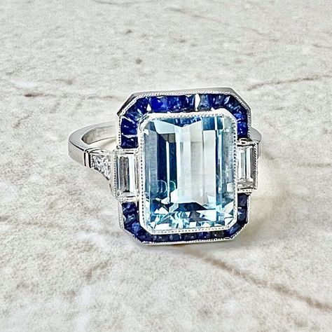 Breathtaking handcrafted platinum Art Deco style aquamarine, sapphire and diamond halo cocktail/engagement ring! It is set with a fine emerald cut aquamarine weighing 3.23 carats (10.02 x 8.07 mm). It is haloed by a row of natural French cut blue sapphires weighing approximately 1/2 carat. It is accented by 2 baguette diamonds and 6 old European cut diamonds weighing approximately 0.35 carat. Fine milgrain add to the delicacy of the ring. Beautiful openwork filigree decorate the under gallery. L: 14.05 mm W: 13.34 mm Band width: 1.78 mm Ring size 6.5 US / M 1/2 UK / 52 3 /4 FR. This ring is part of the Authenticity Guarantee program of eBay. For this reason we are unable to resize if bought on eBay. Please visit our website WeiLJewelry to purchase and resize this ring. Birthstone: March/Ap Art Deco Sapphire Ring, Ruby Diamond Rings, Diamond Halo Ring, Aquamarine Engagement Ring, Aquamarine Jewelry, Aquamarine Rings, Halo Diamond Ring, Art Deco Diamond, Custom Jewelry Design