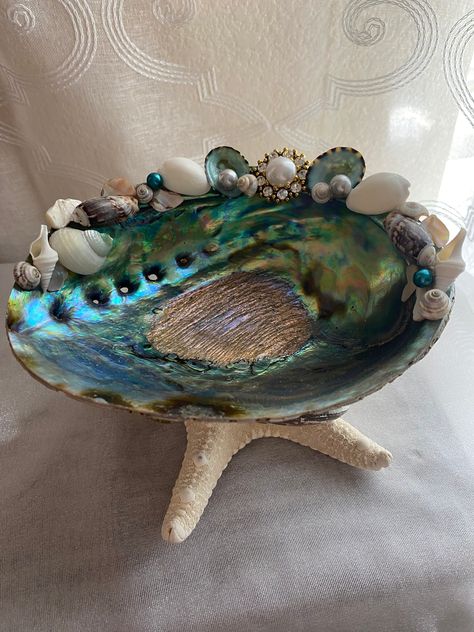 Beautiful abalone jeweled trinket dish. This is an extra large jewelry holder. It is all shells. It sits on a large white starfish. And abalone shells adorn around. There is a faux jewel with various seashells on top. The abalone shell shows beautiful color in it.  It measures 6 in wide, by 4 in. Tall.  Numerous uses for this dish, or just admire the extreme beauty of our Oceans bounty!! Sea Shell Holder, Seashell Jewelry Holder, Abalone Shell Crafts, College Pics, Decoupage Shells, Shells Crafts, Decorative Crosses, Extreme Beauty, Seashell Art Diy